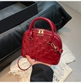 Detalle de bolso tipo concha en charol rojo con relieve de cuadros y cremalleras doradas - Rojo