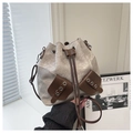 Primer plano del bolso saco con cordón mostrando textura de lona y detalles en cuero - Gris claro
