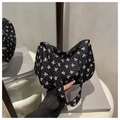 Detalle de bolso bandolera plisado negro con estampados de lazos rosas y textura rizada - Negro