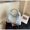 Close-up of light blue embroidered handbag with floral geometric patterns and bead charm - Blue
