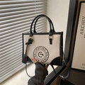 Vintage canvas draagtas in crème en zwart leer met een rond retro-logo en riem - Wit & Zwart