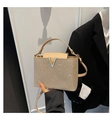 Close-up of beige gold glitter handbag with silver V-shaped buckle and metallic finish - Khaki