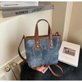 Detail van denim draagtas met lederen handvatten en metalen klinknagels - Blauw