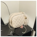 Detail of cream quilted crossbody bag featuring dual zippers and adjustable gold chain strap - White