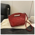 Detalle del bolso de piel charol roja con asa hueca y texto de moda estilo contemporáneo - Rojo