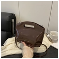 Detail of dark brown glossy patent leather bag with Fashion & Bags text on silk cloth - Coffee