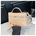 Elegante abrikooskleurige leren crossbodytas met zilveren beslag vastgehouden door hand - Khaki