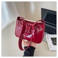 Dettaglio borsa in pelle verniciata rossa con occhielli dorati e decoro coulisse - Rosso