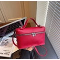 Detalle de bolso tipo caja en cuero granulado rojo con asa superior y herrajes plateados - Rojo