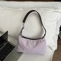 Light purple nylon baguette bag with black leather strap and silver chain on white sofa - Purple
