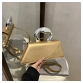 Detail der champagner-goldenen Trapez-Handtasche mit silbernem Flüssigmetallgriff - Gelb