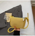 Detail of yellow lychee-textured leather crossbody bag with knot strap and silver zipper - Yellow