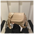 Close-up of beige suede saddle bag featuring decorative stitching and gold metal hardware - Khaki