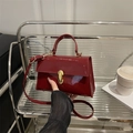 Glossy red patent leather crossbody bag with golden metal buckle and top handle - Red