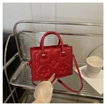 Detail der roten geprägten Tasche mit 3D-Blumenmustern und robusten zylindrischen Griffen - Rot