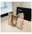 Dettaglio della borsa tote bianca con manici in pelle marrone e catena argentata - Bianco
