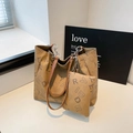 Khaki-Tragetaschen-Set mit schwarzem Buchstabendruck und Metallkette auf weißem Schreibtisch - Khaki