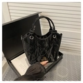 Minimalistische schwarze Beuteltasche mit Knitteroptik, Goldlogo und Rundgriff - Schwarz