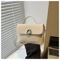 Close-up of cream textured woven flap and silver U-shaped metal buckle on a square bag - White