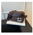 Detail view of a brown vintage geometric crossbody bag with a white graffiti smiley face - Brown