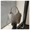 Detail of silver bucket bag with wavy rim, knot handle, and metallic finish surface - Silver