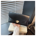Detail of black glossy envelope clutch featuring a unique wavy gold metal clasp - Black