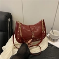 Retro burgundy crescent hobo bag with gold rivets and chain on a soft white background - Red