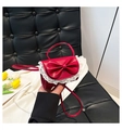 Primer plano detallado de un mini bolso rojo con bordes de encaje y un gran lazo dulce - Rojo