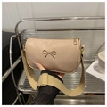 Detalle del bolso de hombro en piel PU beige con lazo dorado y correa tejida - Caqui