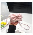 Close-up of pink mini crossbody bag featuring a large bow and white lace floral trim - Pink