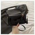 Primer plano del bolso bandolera de charol negro con herrajes dorados y logotipo - Negro