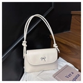 Dettaglio della borsa a tracolla crema con elegante fiocco nero e tracolla a corda - Bianco Sporco