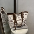 Borsa tote bianca con stampe graffiti e orsetti cartoon su un piedistallo minimalista - caffè