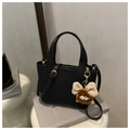 Black litchi pattern bucket bag with brown plush monster charm and top handles - Black With Pendant