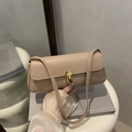 Borsa a tracolla beige chic con texture litchi e chiusura dorata su sfondo minimal - Cachi