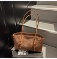 Macro shot of brown retro tote bag featuring knotted handles and vintage leather texture - Coffee