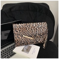 Detail of leopard print envelope clutch featuring gold metal clasp and wrist strap on a desk - Leopard Khaki