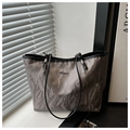 Dettaglio borsa tote grigia con trama marmorizzata, manici in pelle e logo in metallo - Grigio Senza Pendente