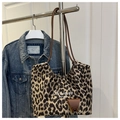 Dettaglio della borsa tote leopardata con testo bianco e ciondolo marrone pendente - Stampa leopardata