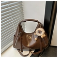 Dettaglio borsa hobo in morbida pelle marrone con cerniere argentate e ciondolo di peluche - Marrone con Pendente