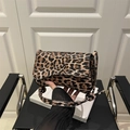 Vintage leopard print shoulder bag with knotted cord strap on a black leather chair - Brown