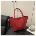 Primer plano de la textura de cocodrilo roja de este bolso tote sobre mesa de madera - Rojo
