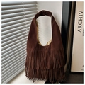 Detailopname van de donkerbruine suède hobo-tas met bohemien franjes en natuurlijke lichtinval - koffiekleur