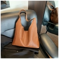 Detailaufnahme der dunkelbraunen Leder-Flechtstruktur einer geräumigen Hobo-Handtasche - Braun