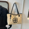 Chique beige grote draagtas met zwarte band en cirkelvormig logo op een witte muur - Khaki Zwart