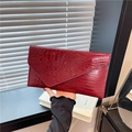 Dark red crocodile texture envelope clutch bag with glossy finish held in hand - Red