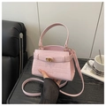 Detalle de bolso rosa claro con patrón de cocodrilo, cierre dorado y correas dobles - Rosa
