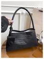 Detailed close-up of the diagonal weave texture on a black faux leather tote bag - Black