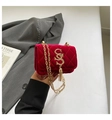 Detail der roten Samt-Stepptasche mit goldenem S-Logo und elegantem Fransenanhänger - Rot