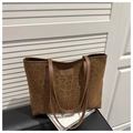 Detailaufnahme der Wildleder-Einkaufstasche mit Leopardenmuster, Markenlogo und Lederecken - Braun